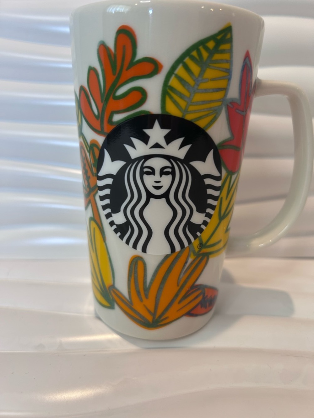 Starbucks White Ceramic Mug with Black Logo and Colorful Leaf Pattern